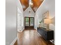 Elegant foyer boasts wood floors, a wooden ceiling, and double doors leading to the outside at 7116 Dumfries Ln, Chapel Hill, NC 27514