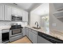 Modern kitchen features stainless steel appliances, light-colored cabinets, and a granite countertop with eat-in breakfast nook at 75 Stone Hill Ct, Durham, NC 27704