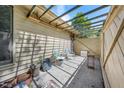 An outdoor patio area with a privacy fence and simple seating arrangement with natural light filtering through overhead trellis at 75 Stone Hill Ct, Durham, NC 27704