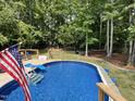 Inviting backyard featuring a pristine pool, perfect for relaxation and outdoor entertainment, framed by lush greenery at 7824 Hemlock Ct, Raleigh, NC 27615