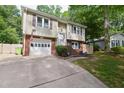 Charming split-level home featuring a brick-accented facade, attached garage, and well-maintained lawn at 7824 Hemlock Ct, Raleigh, NC 27615
