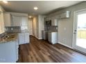 Modern kitchen with sleek gray cabinets, granite countertops, stainless steel microwave, and hardwood flooring at 94 Starry Sky Dr, Benson, NC 27504