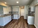 Well-lit kitchen with stainless steel microwave, granite countertops, gray cabinets, and hardwood flooring at 94 Starry Sky Dr, Benson, NC 27504