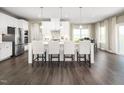 A spacious kitchen with white cabinets, a large island, stainless steel appliances and dark wood floors at 1012 Country Pasture Cv, Wendell, NC 27591
