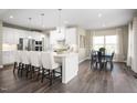 Bright, eat-in kitchen featuring white cabinets, a marble backsplash and dark wood floors at 1012 Country Pasture Cv, Wendell, NC 27591