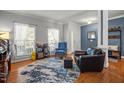 Cozy living room boasts wood floors, two large windows, a stylish blue accent wall and comfy furniture at 1028 Bellenden Dr, Durham, NC 27713