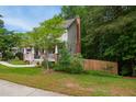 Suburban home featuring a lush front yard, mature trees, a charming covered front porch, and sidewalk at 1102 Whiston Dr, Apex, NC 27502