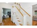 Bright entryway featuring a staircase with wood handrail, white risers and painted wood-paneled walls at 1102 Whiston Dr, Apex, NC 27502