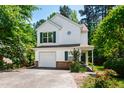 Charming two-story home with white siding, green shutters, attached garage, and mature trees at 12 Byerly Ct, Durham, NC 27713