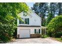 Charming two-story home with white siding, green shutters, attached garage, and mature trees at 12 Byerly Ct, Durham, NC 27713