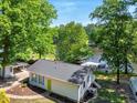 Charming lake house with a view, featuring a boat dock, inviting outdoor deck, and bright, colorful shutters at 135 Sagamore Dr, Louisburg, NC 27549