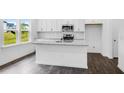 Bright kitchen with granite countertops, stainless steel appliances, and white cabinets with dark hardwood floors at 174 Hickory Grove Dr, Sanford, NC 27330