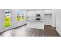Bright kitchen with granite countertops, stainless steel appliances, and white cabinets with dark hardwood floors at 174 Hickory Grove Dr, Sanford, NC 27330