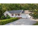 Home featuring a 2-car garage, manicured lawn, and charming front porch at 205 Smiths Creek Dr, Clayton, NC 27520