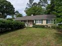 Lovely exterior of a tan home featuring green shutters and a well-kept lawn at 2143 Ridge Rd, Raleigh, NC 27607