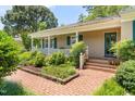 A charming home exterior featuring a cozy porch and neatly arranged garden at 2143 Ridge Rd, Raleigh, NC 27607