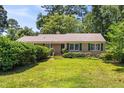 Traditional home featuring a green lawn, mature landscaping, and classic shutters at 2143 Ridge Rd, Raleigh, NC 27607