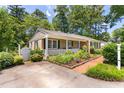 Home with charming front porch, landscaped garden, brick path, and gated entrance at 2143 Ridge Rd, Raleigh, NC 27607