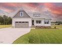 Charming single Gathering home with a 2-car garage, white siding, a covered porch and green grass at 24 Sanders Farm Dr, Smithfield, NC 27577