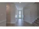 Bright hallway with wood floors, white molding and trim, a door with glass, and stairs nearby at 24 Sanders Farm Dr, Smithfield, NC 27577