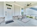 Cozy front porch seating area with outdoor rug, seating and ceiling fan at 2848 Angelica Rose Way, Apex, NC 27502