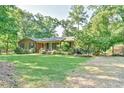 Landscaped front yard featuring a brick home and a fenced yard at 308 Rainbow Dr, Carrboro, NC 27510