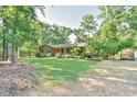 Landscaped front yard featuring a brick home and a fenced yard at 308 Rainbow Dr, Carrboro, NC 27510