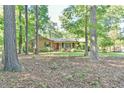 Serene exterior view of a brick home nestled amongst mature trees at 308 Rainbow Dr, Carrboro, NC 27510