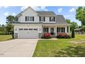 Charming two-story home boasts a well-manicured lawn, attached garage, and inviting front porch at 3409 Lemon Springs Rd, Sanford, NC 27332