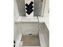 Interior design elements showcase navy backsplash, white cabinets, and light wood flooring at 343 Chesapeake Cmns St # 109, Garner, NC 27529