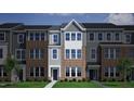 A townhome displays a color scheme of gray siding, brick, and white trim, emphasizing modern architectural design at 347 Chesapeake Cmns St # 110, Garner, NC 27529
