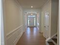 Bright hallway features elegant trim, wood floors and a view of the front door at 38 Gander Dr, Benson, NC 27504