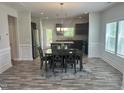 Open dining area featuring hardwood floors, modern lighting, and an adjacent open kitchen space at 42 Hemming Ct, Cameron, NC 28326