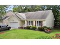 Single-story home with attached garage, verdant lawn, and flowerbed at 4705 Forest Highland Dr, Raleigh, NC 27604