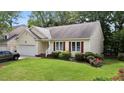 Single-story home with attached garage, verdant lawn, and flowerbed at 4705 Forest Highland Dr, Raleigh, NC 27604