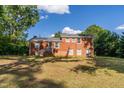 Expansive backyard with brick house and staircase in a serene, tree-lined setting at 4813 Glen Forest Dr, Raleigh, NC 27612
