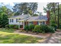 Charming two-story home with brick accents, blue shutters and mature trees at 4813 Glen Forest Dr, Raleigh, NC 27612