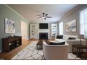 Stylish living room boasting a cozy fireplace, built-in shelves, ceiling fan, and modern furniture arrangement at 4813 Glen Forest Dr, Raleigh, NC 27612
