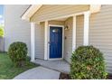 Inviting entryway with a blue front door, white pillars, and manicured bushes at 5416 Kissimmee Ln, Raleigh, NC 27616