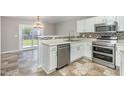 Well-lit kitchen featuring white cabinets, stainless steel appliances, and stylish backsplash at 5416 Kissimmee Ln, Raleigh, NC 27616