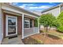 Brick front porch with white railings and a storm door leading to the entrance of the home at 5420 Roan Mountain Pl, Raleigh, NC 27613
