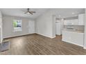 Open-concept living area with fireplace, connecting to a kitchen with white cabinets and appliances at 5420 Roan Mountain Pl, Raleigh, NC 27613