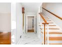 Bright entryway with white marble floors, wooden staircase, and classic accents at 5513 Parkwood Dr, Raleigh, NC 27612