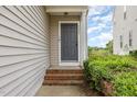 Inviting front entrance with a gray door, brick steps, and lush green bushes providing curb appeal to the home at 5622 Osprey Cove Dr, Raleigh, NC 27604