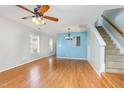 Bright living room featuring hardwood floors, a ceiling fan, and stairway to the upper floor at 5622 Osprey Cove Dr, Raleigh, NC 27604