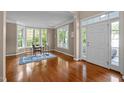 Home office area featuring hardwood floors, bright light from many windows, and an elegant desk at 606 Churton Grove Blvd, Hillsborough, NC 27278