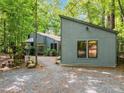 Exterior of the home and detached structure with a gravel yard and surrounding trees at 61 Stone Ledge, Pittsboro, NC 27312