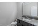 Stylish powder room featuring a modern vanity, gray countertop, and a sleek rectangular mirror at 66 Sanders Farm Dr, Smithfield, NC 27577