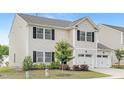 Charming two-story home featuring a two-car garage, black shutters, and well-maintained landscaping at 69 Curling Creek Dr # I286, Clayton, NC 27527
