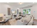 Bright living room featuring hardwood floors, a stylish entertainment center, and large windows at 69 Curling Creek Dr # I286, Clayton, NC 27527